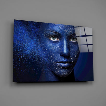 Blue-toned woman's face with glittering effect mounted on wall, partially overlapped by white and navy glass panels.