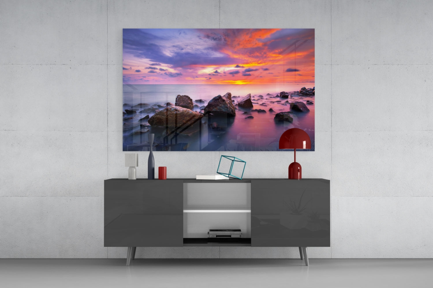 Sunset at Sea Glass Wall Art mounted above dark gray media console with decorative items and shelving in modern living room setting.