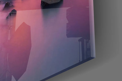 Angled view of glass wall art displaying pink and purple gradient sunset scene with palm trees and building silhouettes.