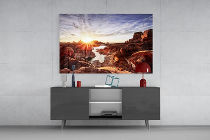 Canyon and Sunset Glass Wall Art hung above gray media console, displaying rocky landscape with sun rays and water reflections.