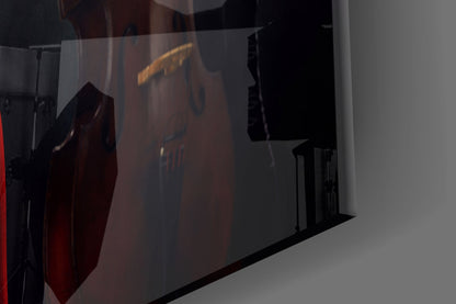 Translucent glass wall art featuring silhouettes of female musicians in dark tones with warm amber lighting effects visible through the glass.