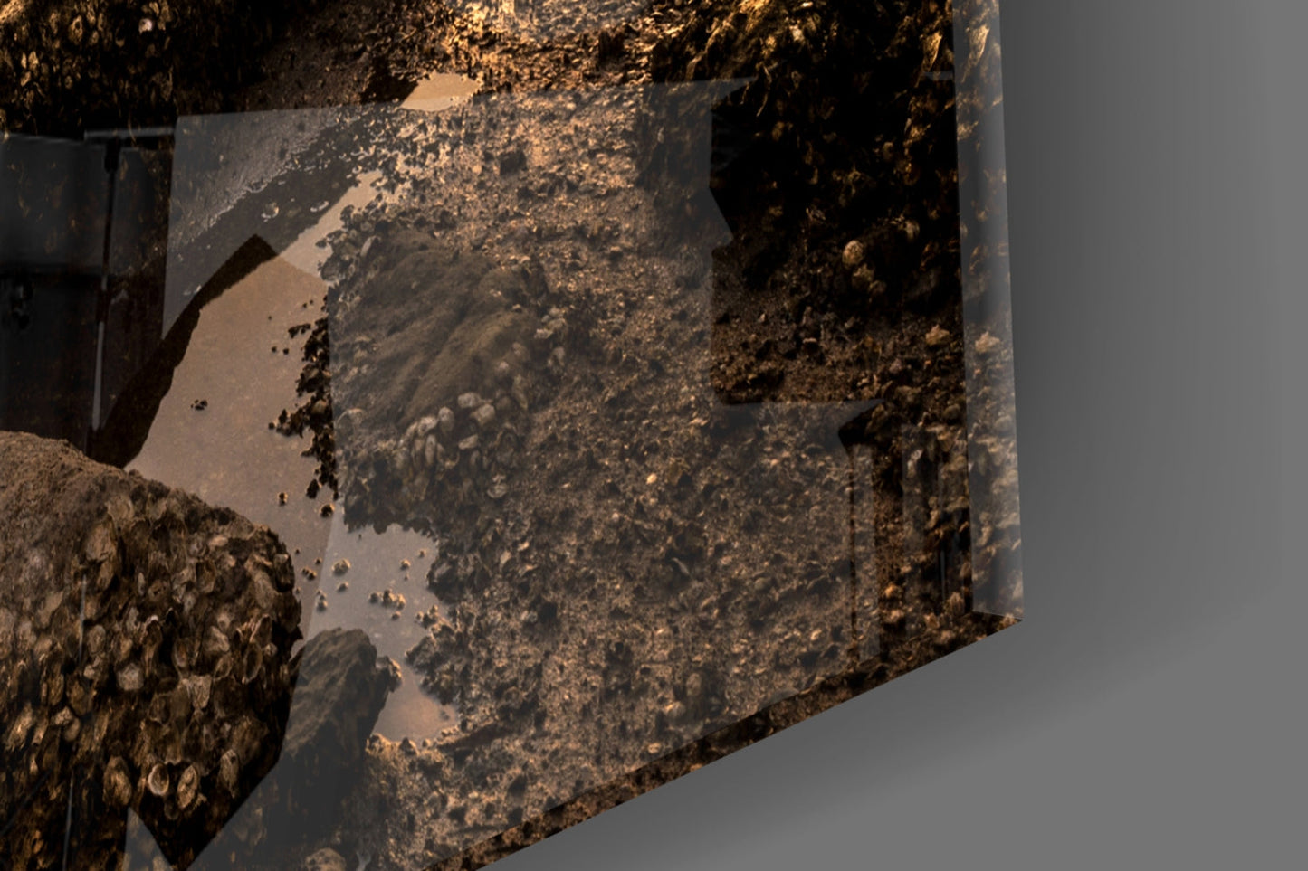 Close-up detail of textured glass wall art showing layered brown and gold tones with rusted metal surface effects and shadows.