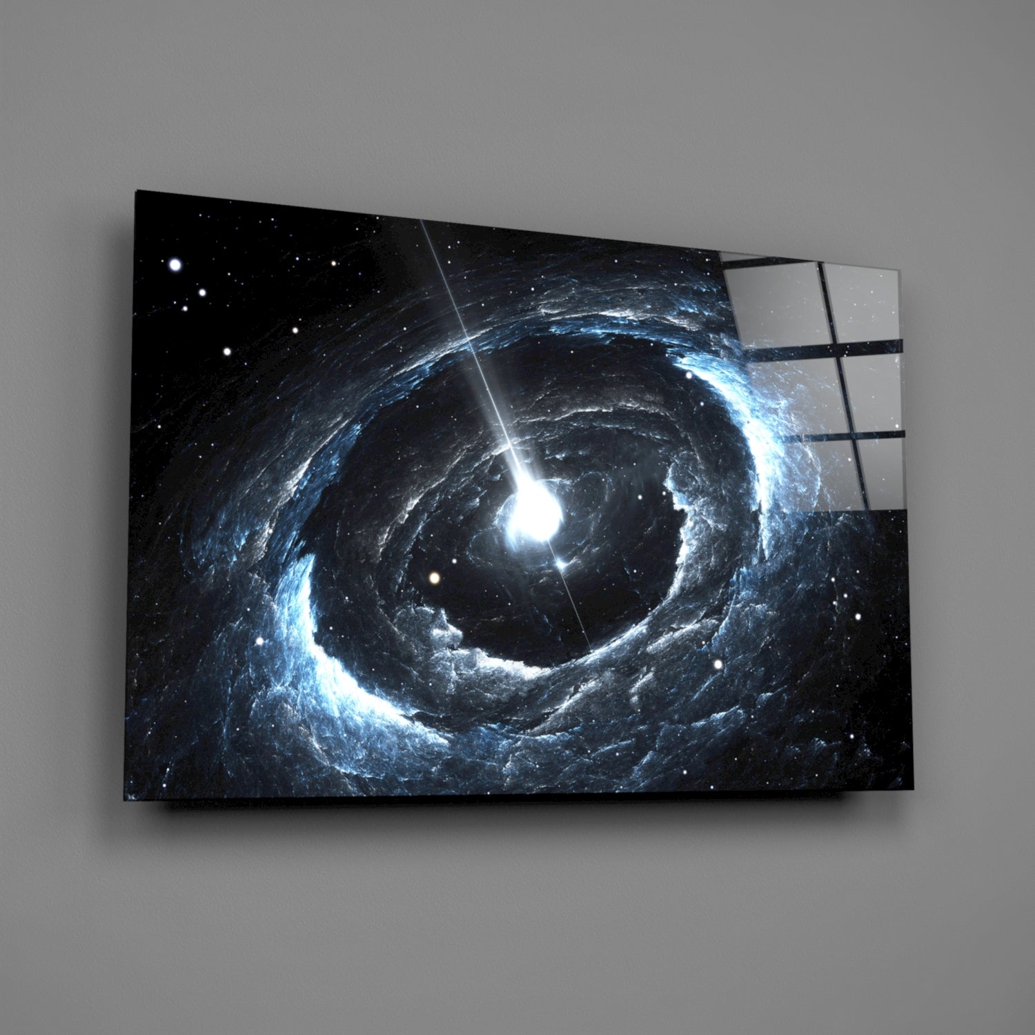 Angled view of glass wall art displaying a blue and white spiral galaxy with bright central light against black starfield background.