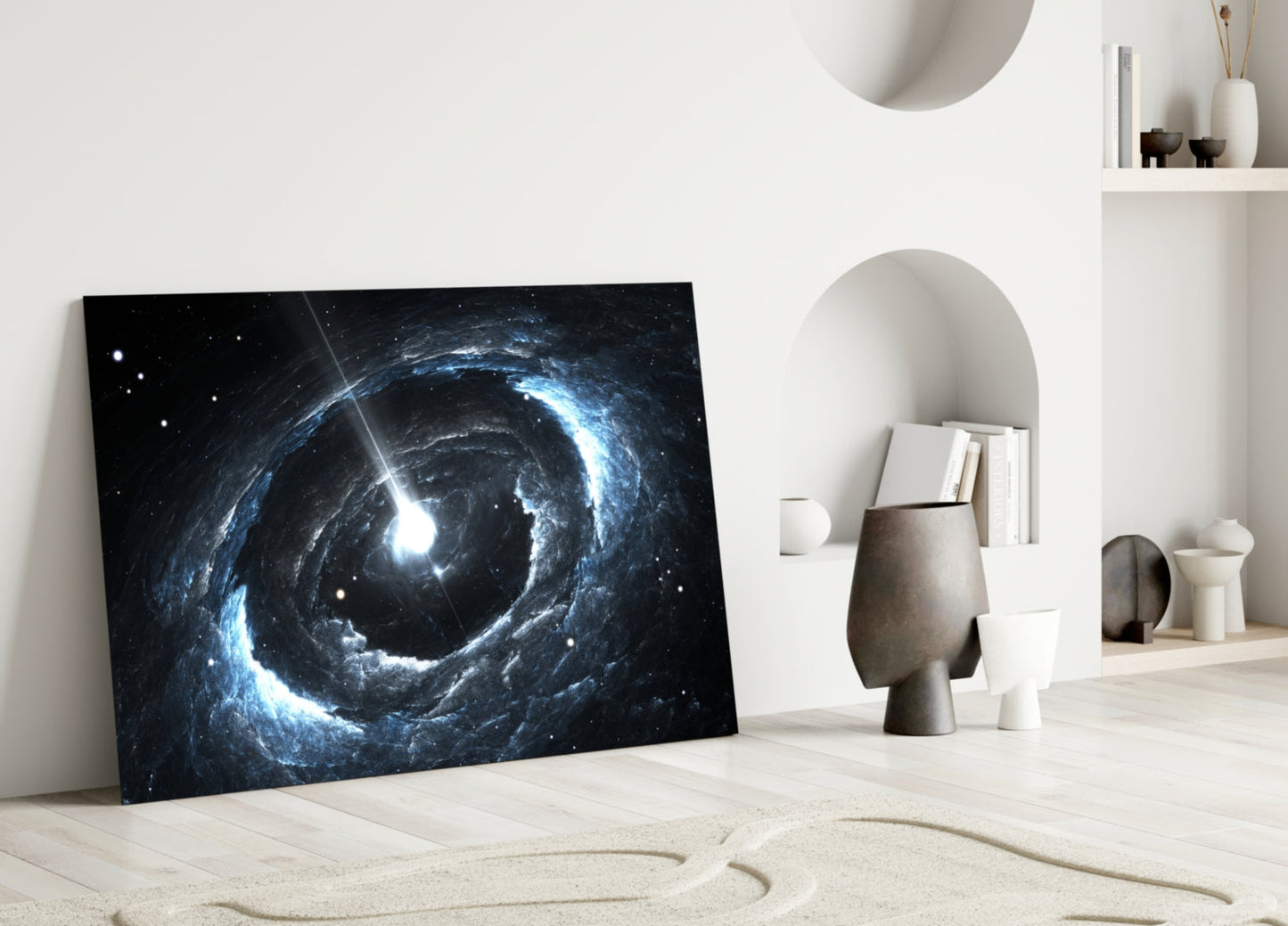 Cosmos Glass Wall Art leaning against white wall in minimalist interior with blue spiral galaxy design and bright light rays on black background.