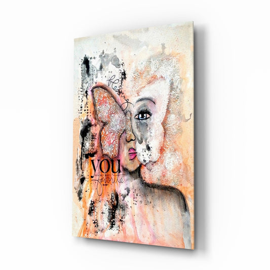 Angled side view of glass wall art featuring a woman's face with peach, orange, and white tones, butterfly wing detail, and "you" and "favorite" text overlays.