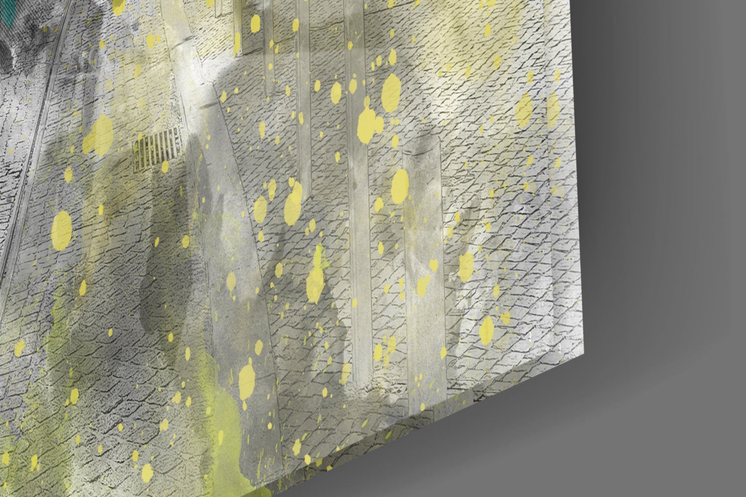 Close-up angled view of textured brick wall with yellow paint splatters and vertical concrete dividers against gray background.