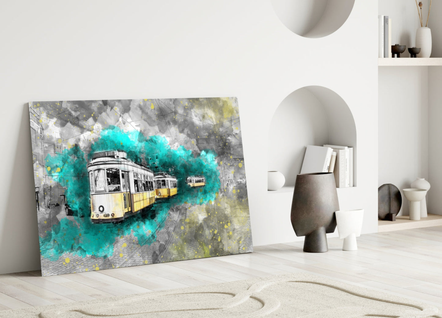 Glass wall art depicting yellow and white trams with turquoise watercolor splashes displayed leaning against white interior wall with shelving.