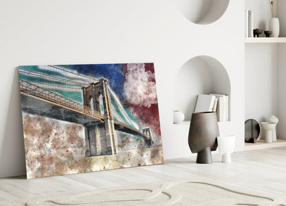 Glass wall art leaning against white wall displaying watercolor Brooklyn Bridge with turquoise sky and textured beige base.