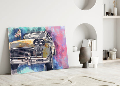 Colorful glass wall art of a vintage yellow taxi displayed on white floor against minimalist interior with shelves and decorative objects.