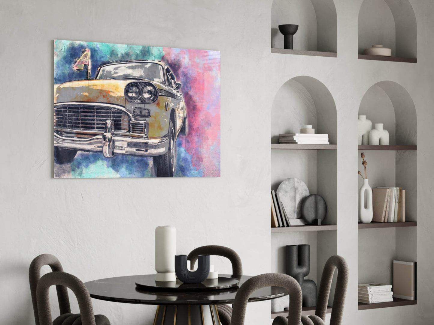 Yellow taxi cab with watercolor blue and pink background displayed on wall above black round dining table with gray chairs.