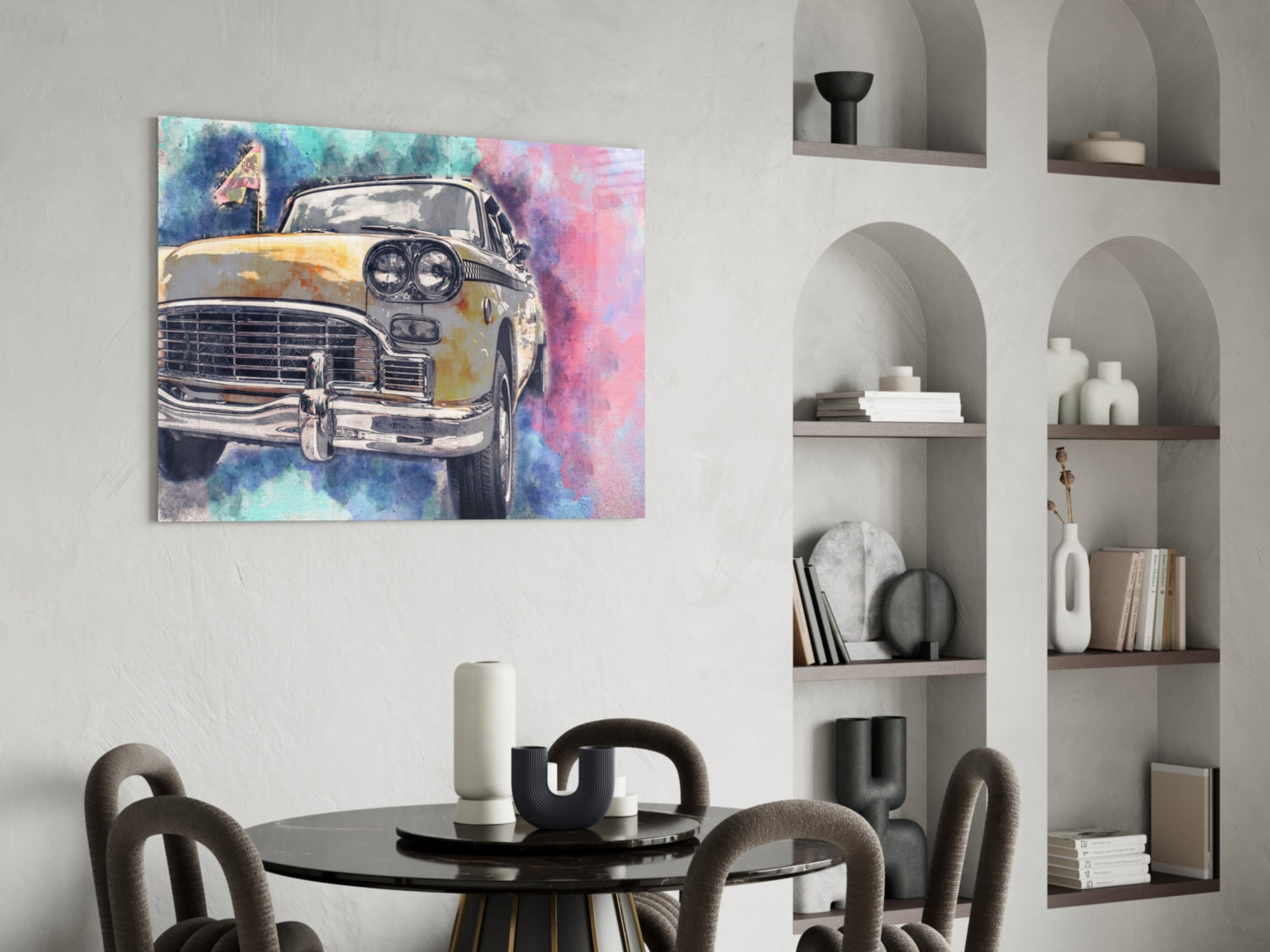 Yellow taxi cab with watercolor blue and pink background displayed on wall above black round dining table with gray chairs.
