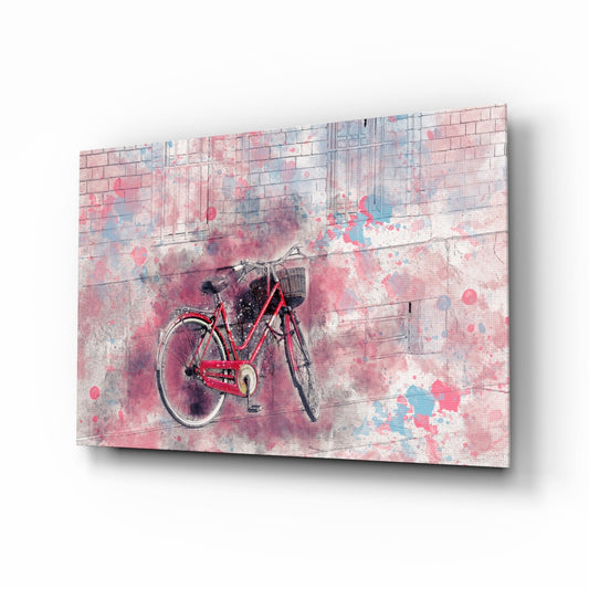 Red bicycle with basket against pink brick wall with watercolor splashes on angled glass art panel.
