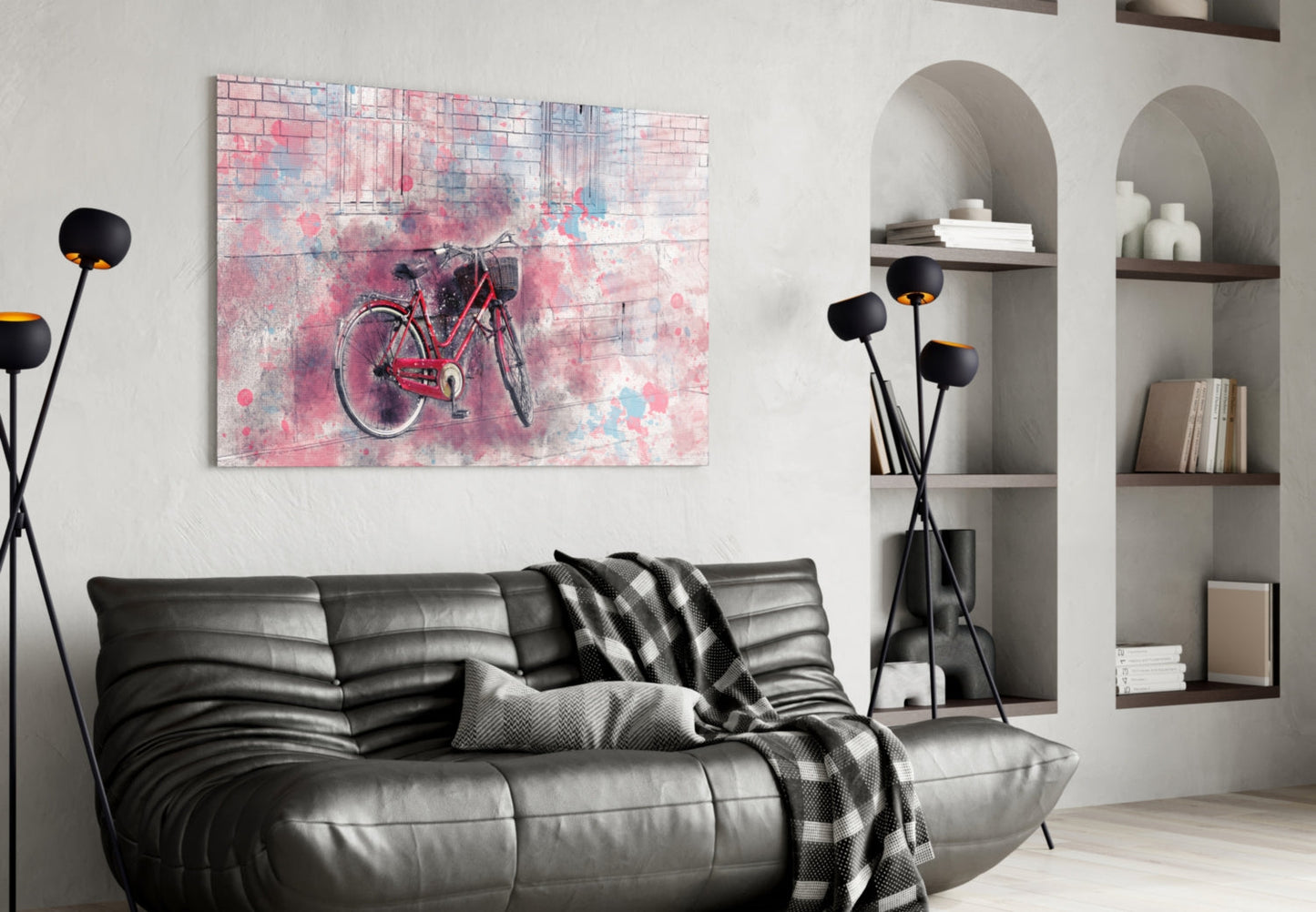 Pink and blue watercolor bicycle glass wall art displayed above black leather sofa in modern living room interior.