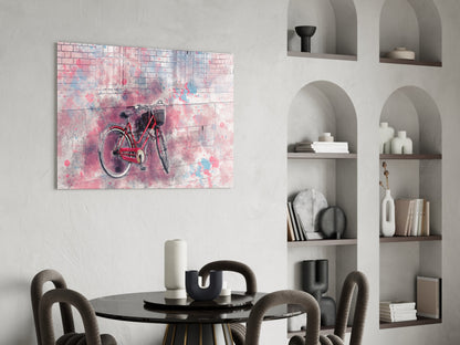 Red bicycle with watercolor pink and blue splashes on glass wall art above dining table in modern interior.