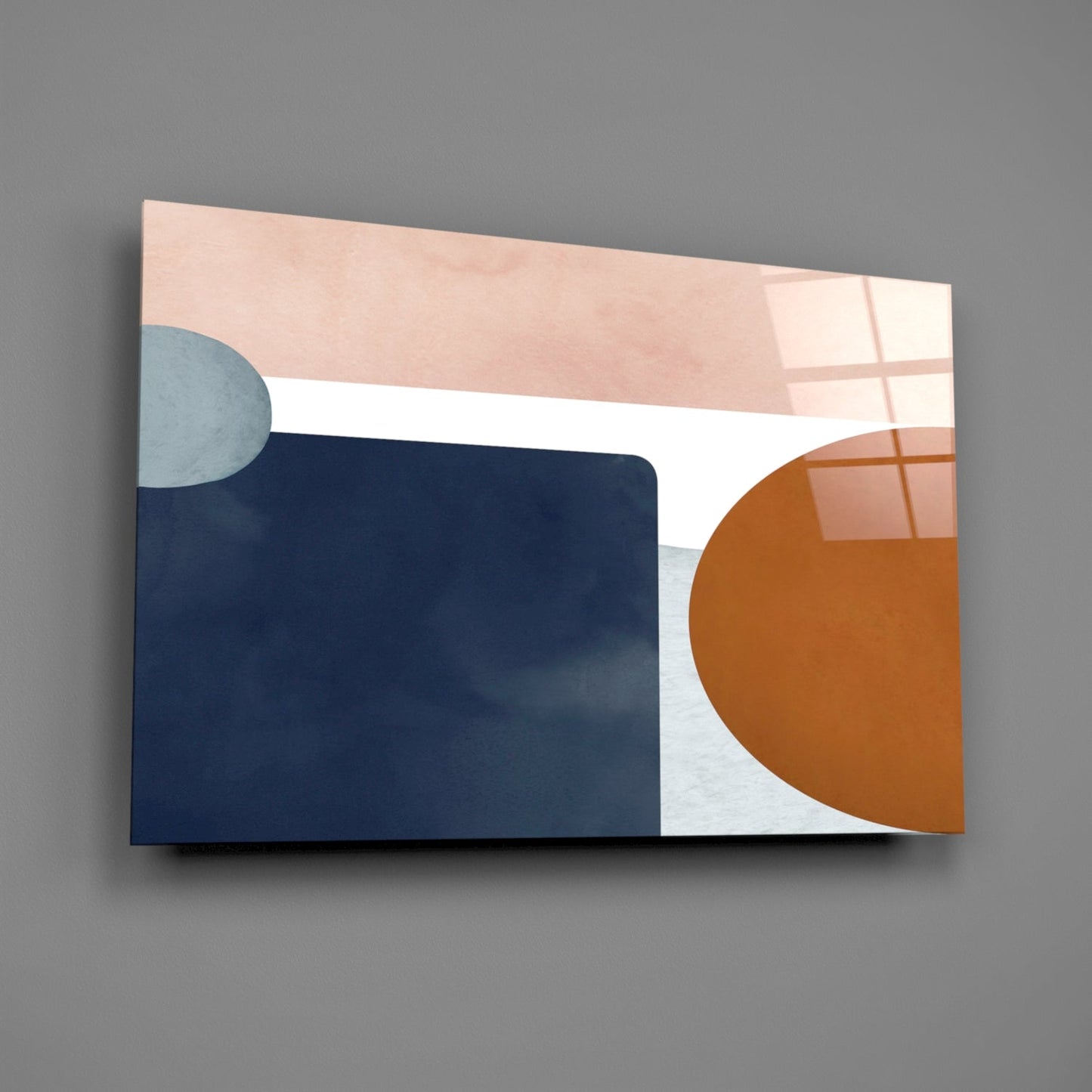 Abstract geometric glass wall art featuring soft pink, navy blue, white, and terracotta shapes with window reflections, angled perspective view.