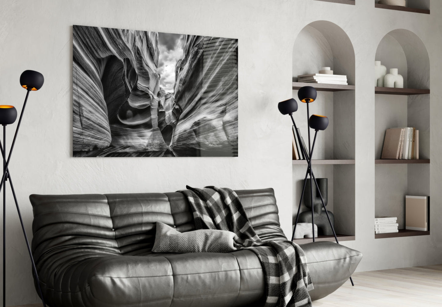 Black and white canyon landscape glass wall art displayed above gray leather sofa in modern living room interior.
