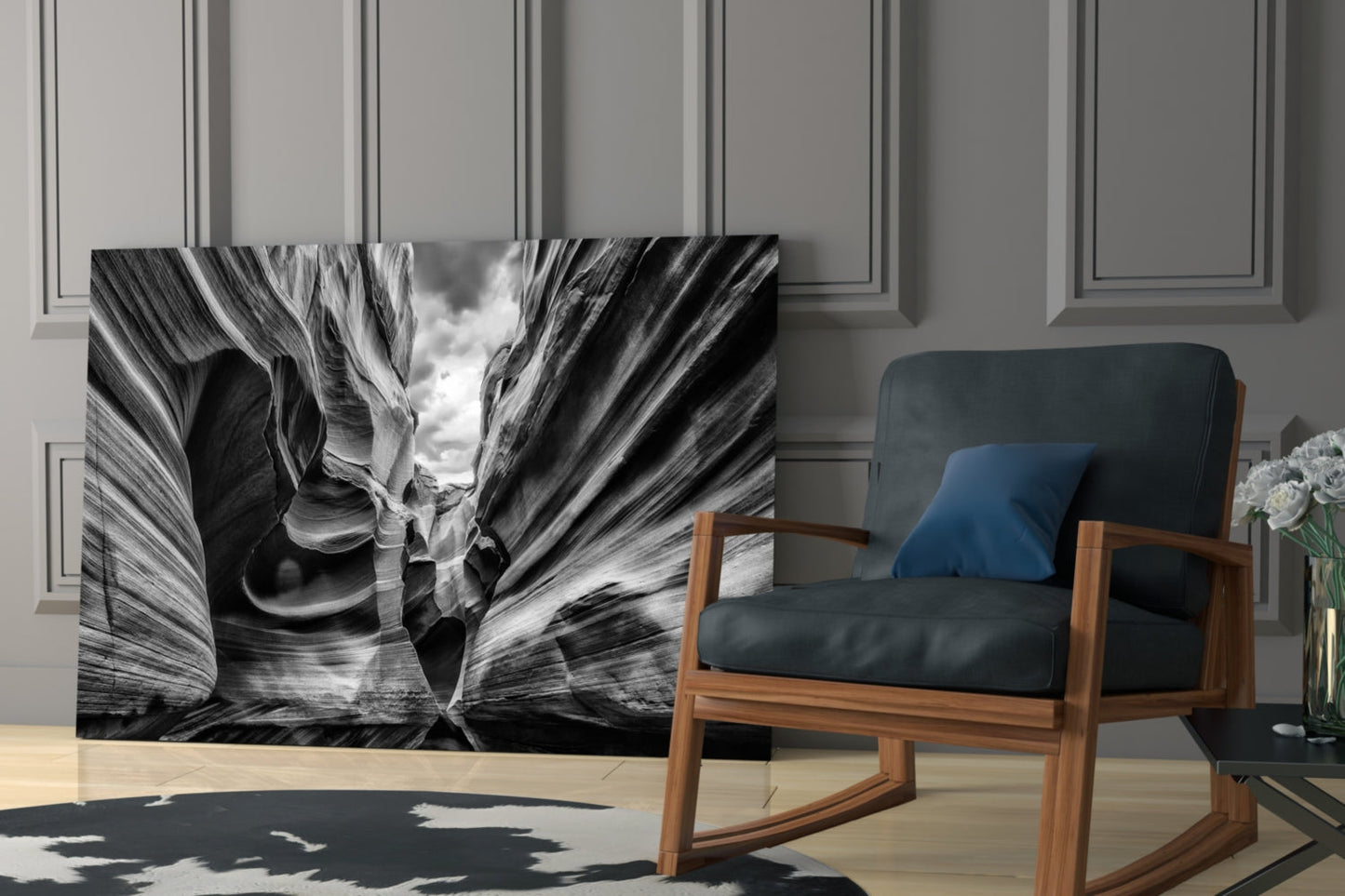Black and white glass wall art depicting layered canyon rock formations displayed in a modern living room beside a wooden chair.