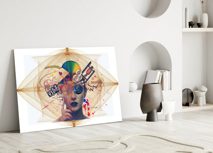Colorful abstract glass wall art featuring a geometric face with overlaid symbols and splashes, leaning against a minimalist white interior wall.