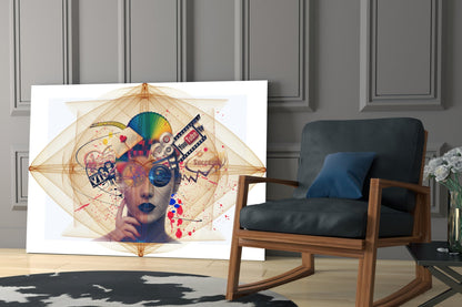 Colorful abstract portrait glass wall art featuring geometric patterns, rainbow colors, and text elements displayed in modern living room next to wooden chair.