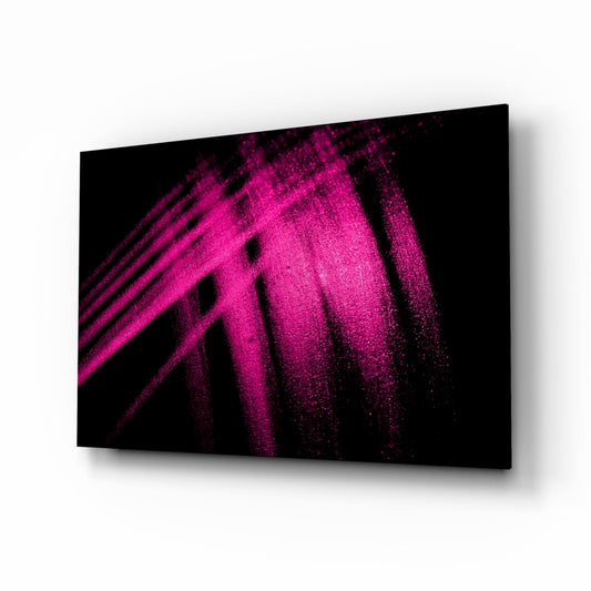 Angled perspective view of magenta powder streaks dispersing across black glass surface with shadow cast on white background.