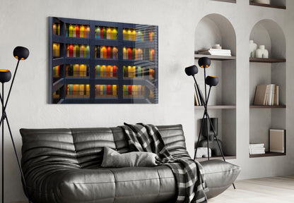 Modern living room with black leather sofa displaying colorful illuminated library glass wall art above it.