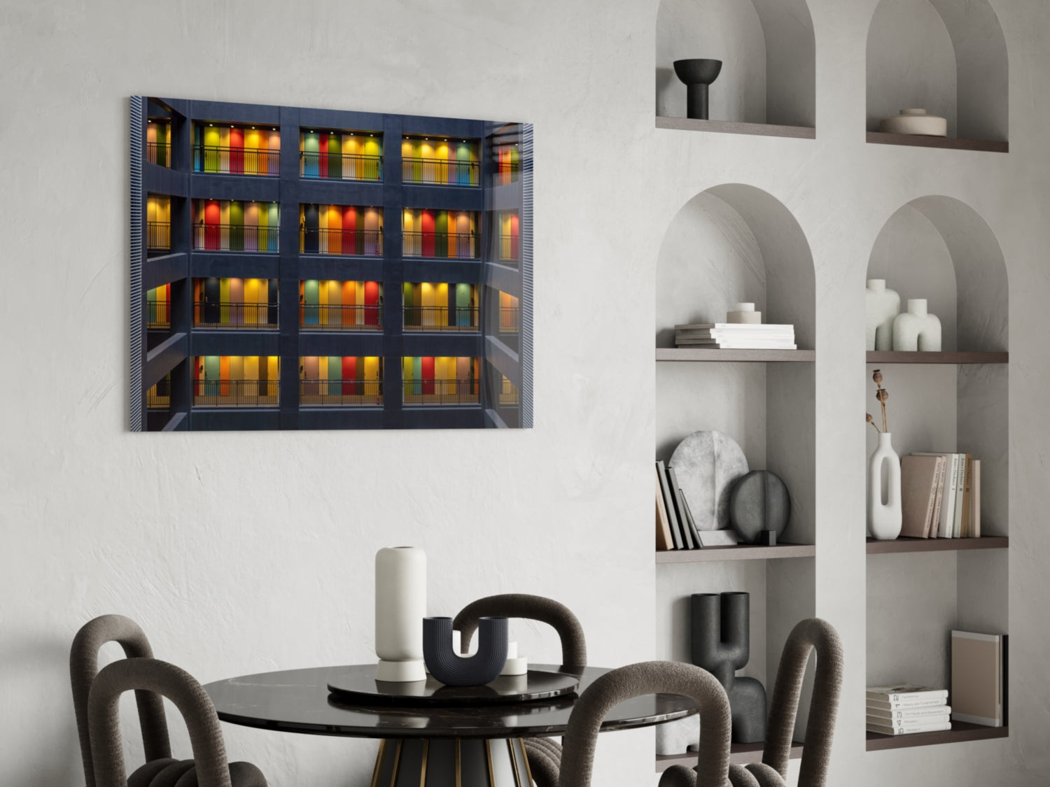 Colored Doors Glass Wall Art displaying illuminated colorful books on dark shelving, hung above a modern dining table with grey chairs.