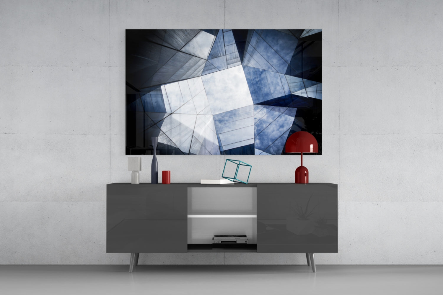 Modern living room with geometric glass wall art mounted above gray media console, featuring blue, white, and black architectural patterns with red decorative accents.