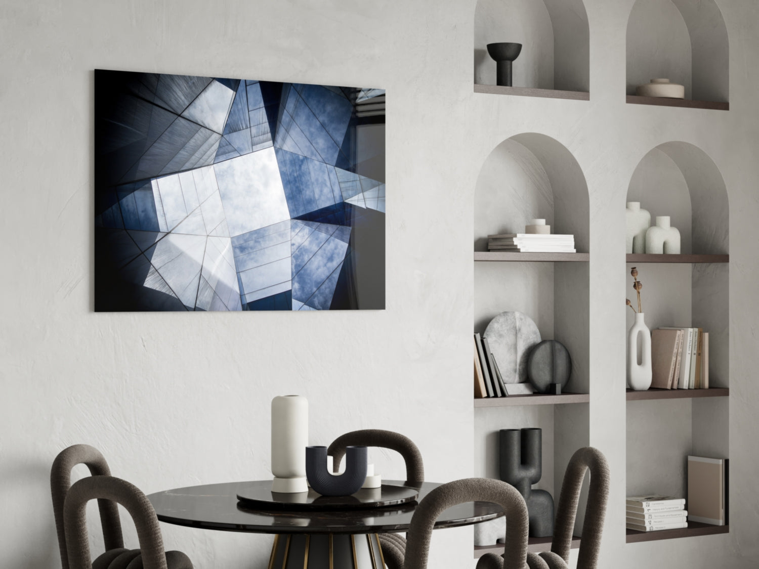 Modern dining room with geometric architecture glass wall art displaying blue and white building facade above black round table and gray chairs.