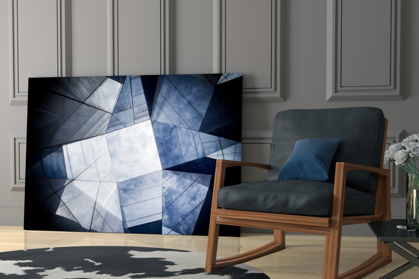 Modern living room with geometric glass wall art displaying blue and white angular patterns displayed next to mid-century wooden chair.