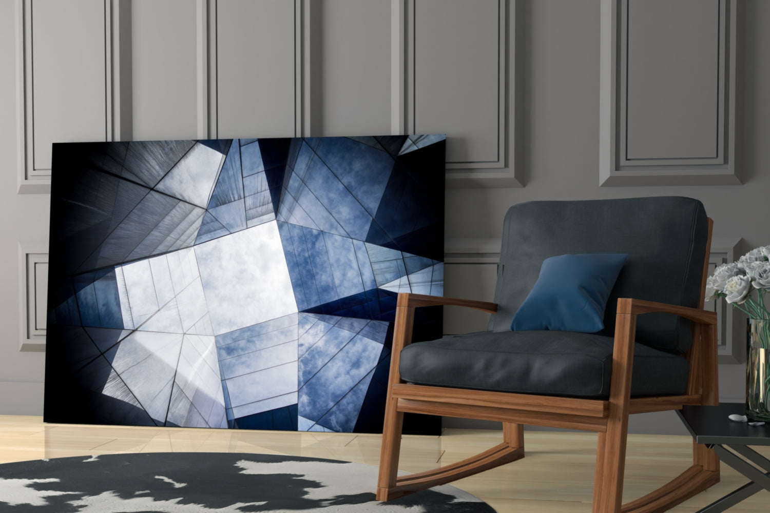 Modern living room with geometric glass wall art displaying blue and white angular patterns displayed next to mid-century wooden chair.