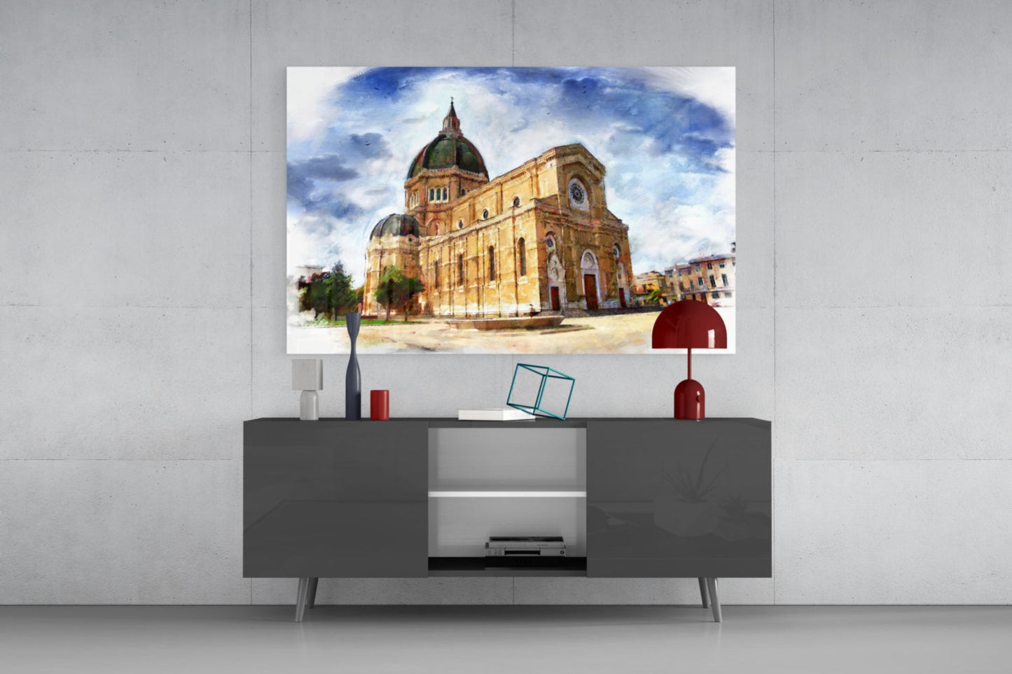 Glass wall art depicting a yellow brick cathedral with green domes displayed above a dark gray media console in a modern living room.