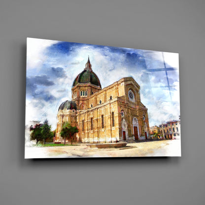 Watercolor painting of a tan brick cathedral with green dome and cross displayed on glass wall art against gray background.