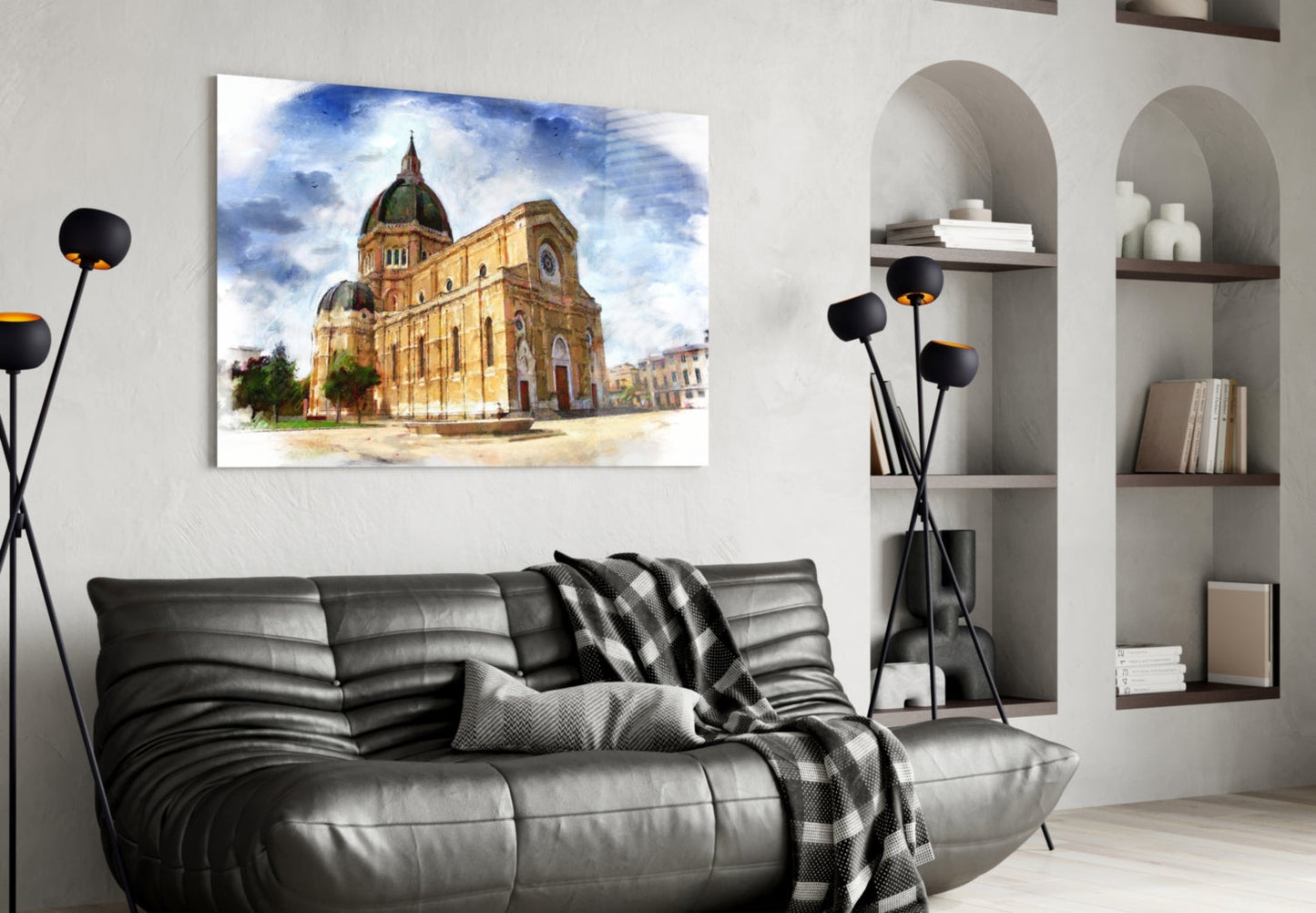 Glass wall art print of a golden cathedral with green dome displayed above a black leather sofa in a modern living room.