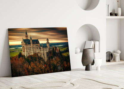 Castle glass wall art leaning against white wall in minimalist room with decorative objects and shelving.
