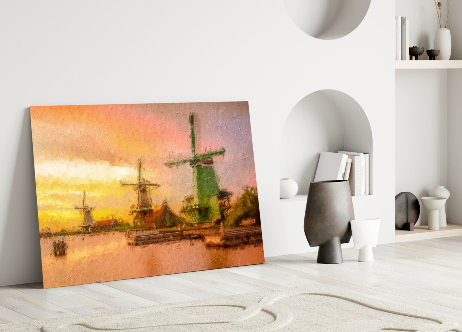 Windmills glass wall art leaning against white wall in minimalist room with sand pattern floor and decorative shelving.