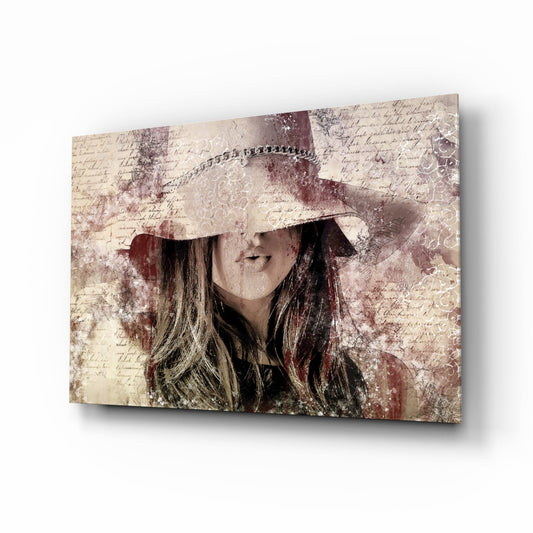 Angled view of glass wall art featuring a woman wearing a cream cowboy hat with long dark hair, overlaid on vintage handwritten text and burgundy distressed patterns.