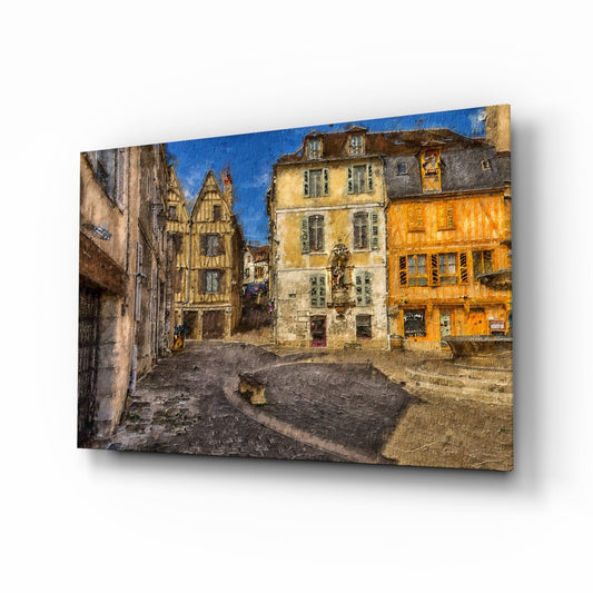 Medieval square glass wall art displayed at an angle, showing a European stone plaza with half-timbered and yellow buildings beneath blue sky.