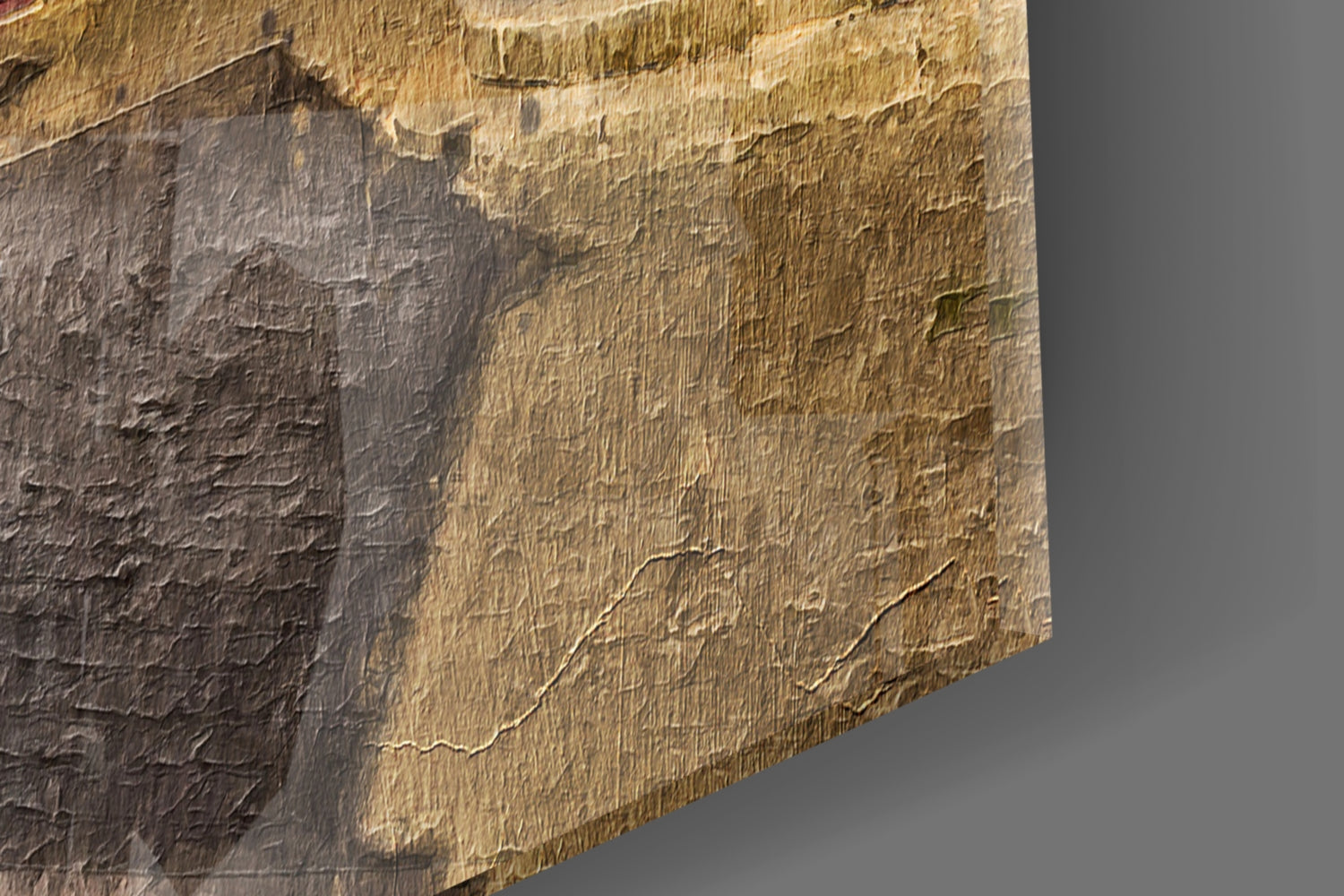 Close-up angled view of textured glass surface showing gold and gray tones with embossed detail.