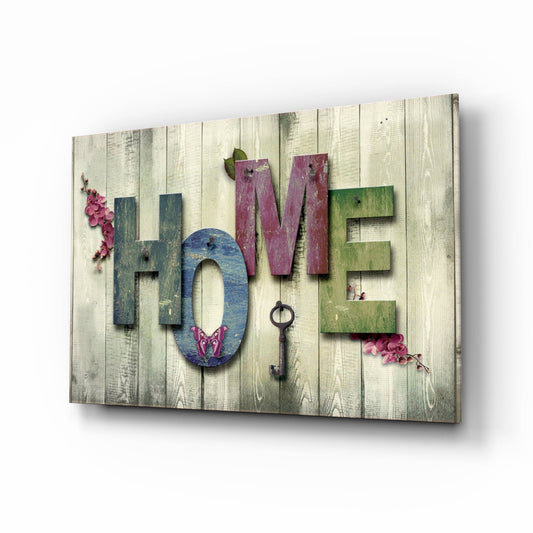 Angled perspective view of a whitewashed wooden panel displaying colorful 3D letters spelling "HOME" with decorative pink flowers and an ornamental key.