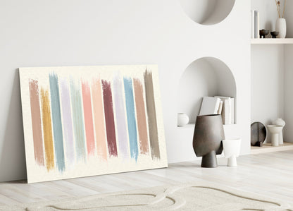 Colored Lines Glass Wall Art leaning against white wall in minimalist room setting with decorative objects and shelving.