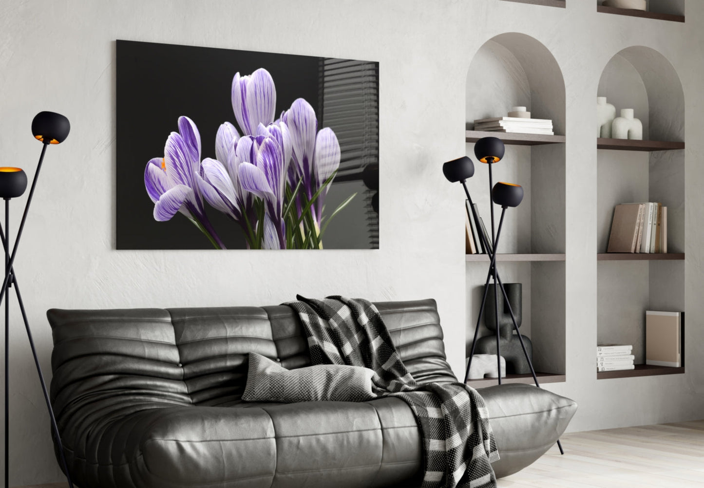 Purple crocus flowers on black glass canvas displayed above gray leather sofa in modern living room interior.