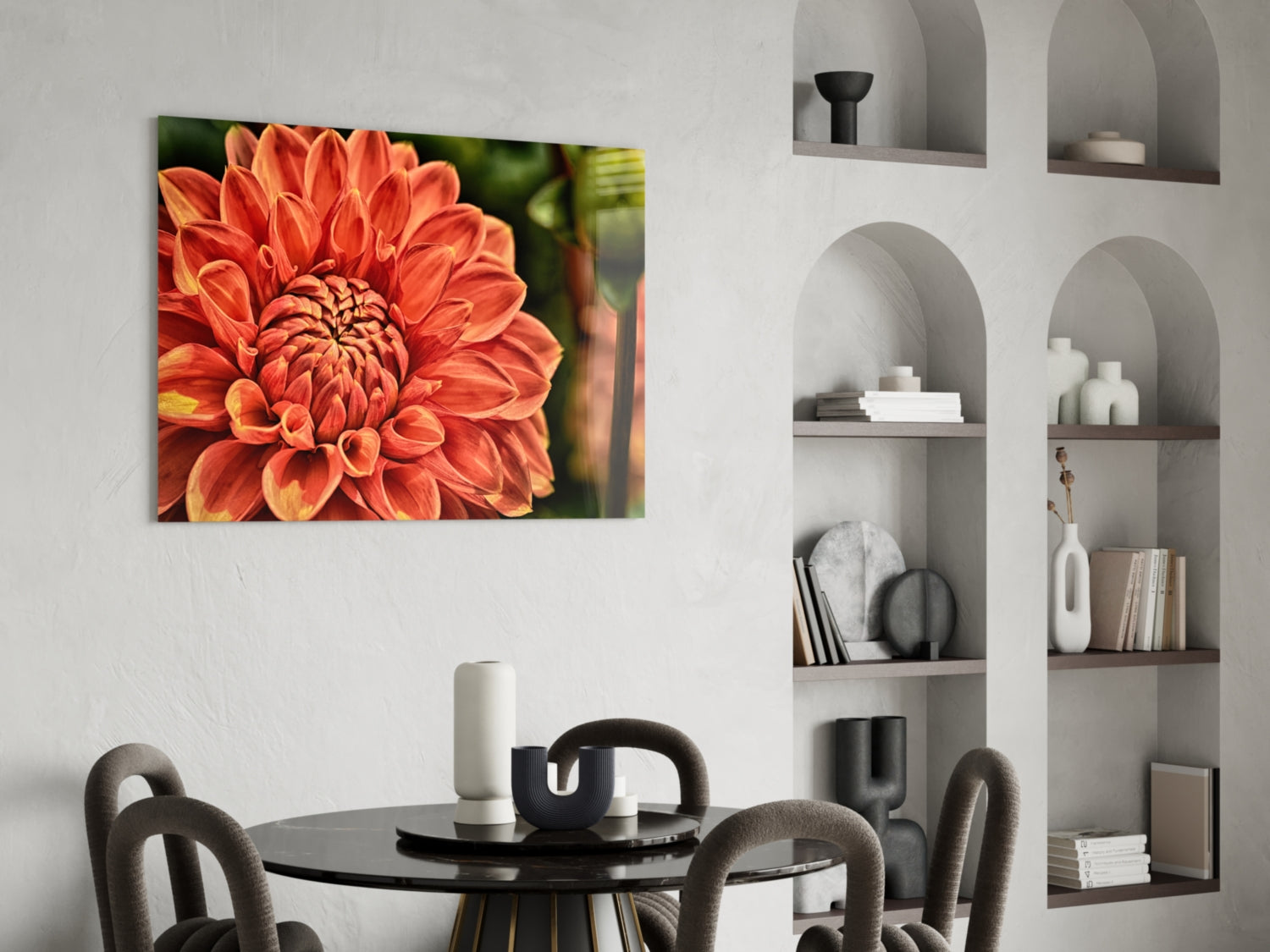 Orange Gerbera glass wall art displayed above a black dining table in a modern room with built-in shelving.