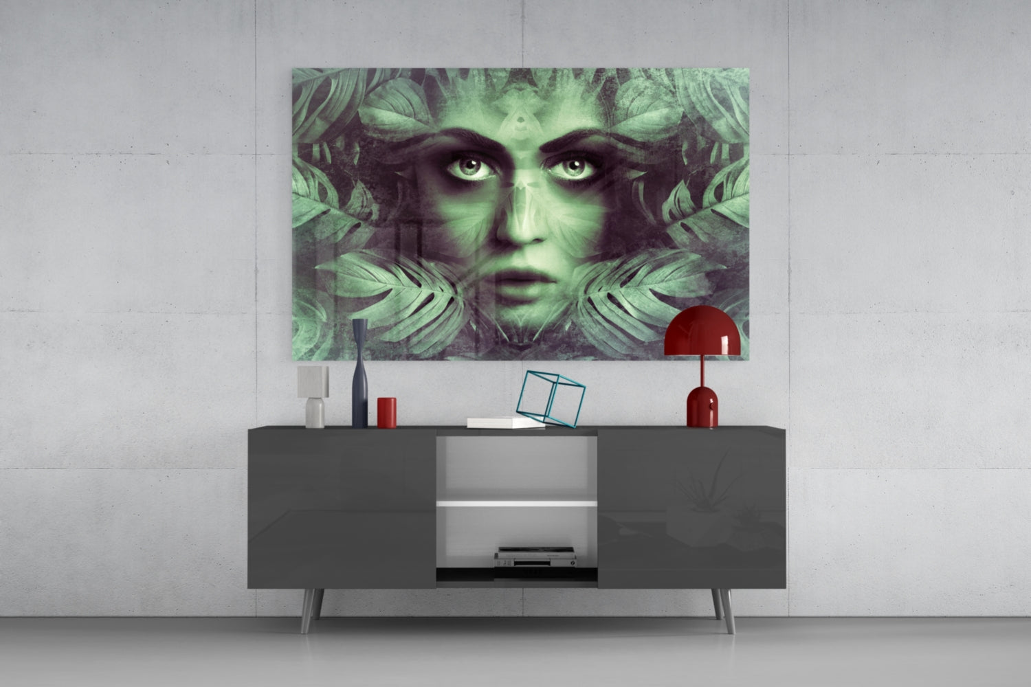 Green and black glass wall art featuring a woman's face with tropical leaves displayed above a dark media console in a modern living room setting.