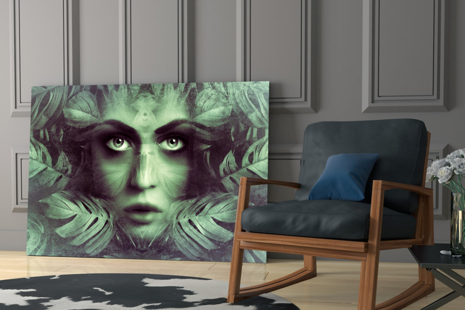 Green-toned glass wall art depicting a woman's face with large eyes surrounded by tropical leaves, displayed in a modern living room next to a wooden chair.