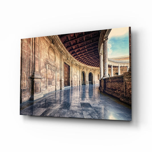 Canvas print of a sunlit Renaissance courtyard with ornate stone columns, arched doorways, and wet marble flooring reflecting light.