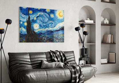 Van Gogh's Starry Night glass wall art hanging above a black leather sofa in a modern living room with shelving.