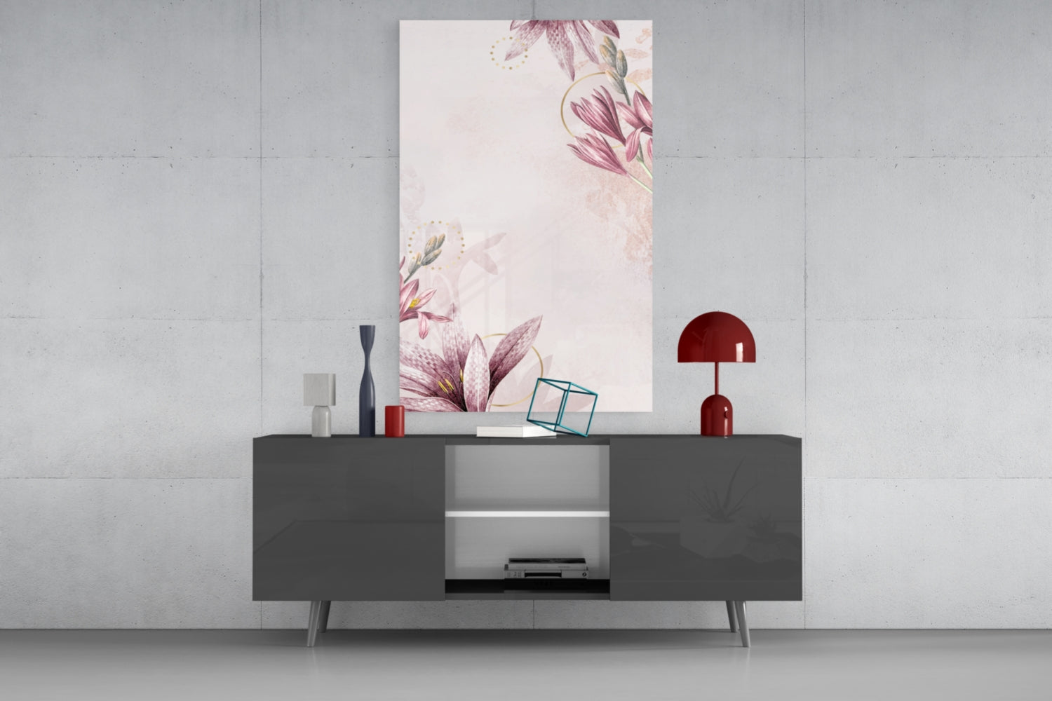 Pink flower pattern glass wall art displayed above dark gray credenza with red lamp and decorative objects on concrete wall.