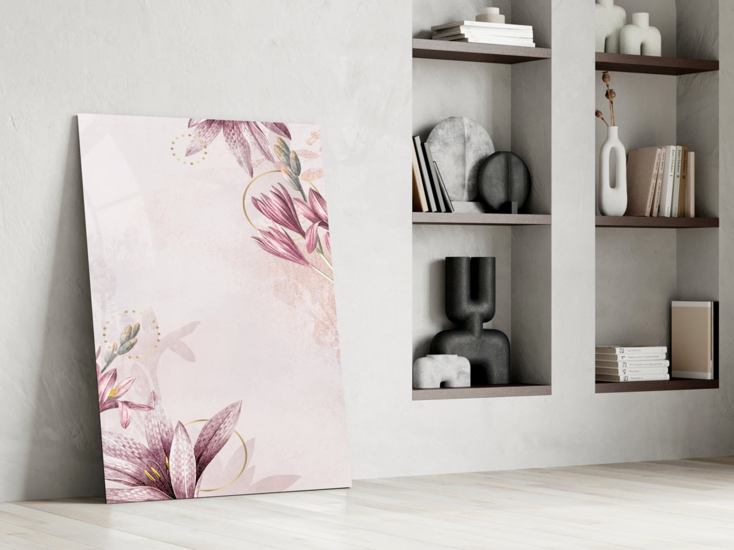 Pink flower glass wall art leaning against white wall beside modern shelving unit with decorative objects.