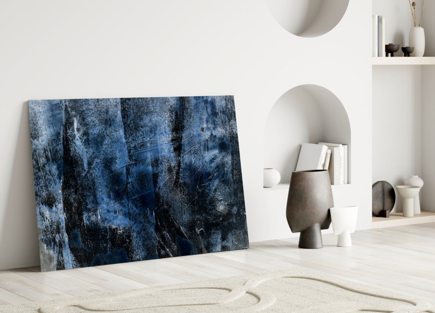Blue abstract textured glass panel leaning against white wall in minimalist room with ceramic decor.
