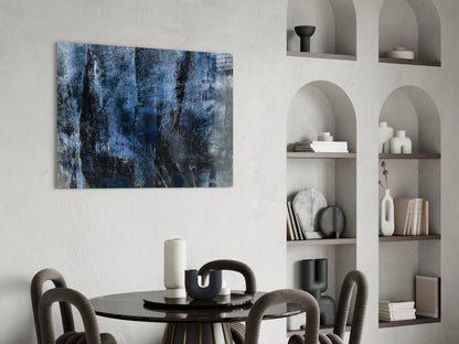 Blue and black abstract textured glass art panel hanging above a round black dining table with gray chairs in a modern interior with built-in shelving.